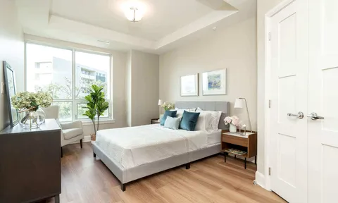 Bedroom with double bed beside large windows