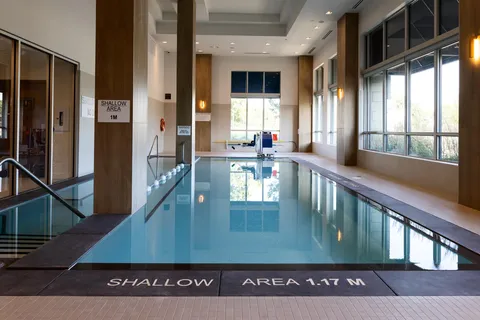 Indoor swimming pool beside tall windows