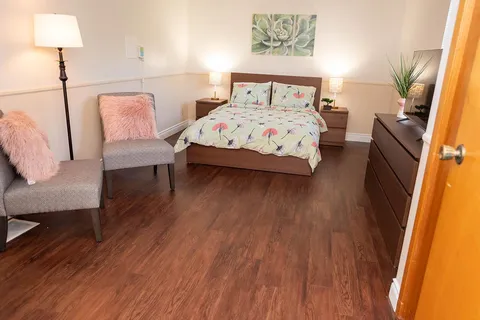 Furnished bedroom with a double bed and armchairs.