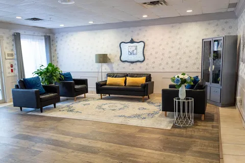 Front lounge with sofas, armchairs and patterned wallpaper.