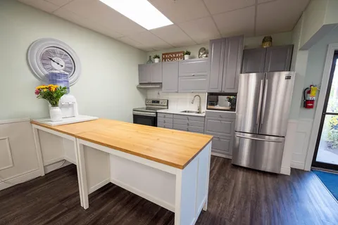 Kitchen area with cabinets, appliances and a central island.
