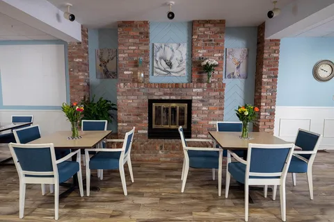 Seating beside a brick fireplace in the dining area.