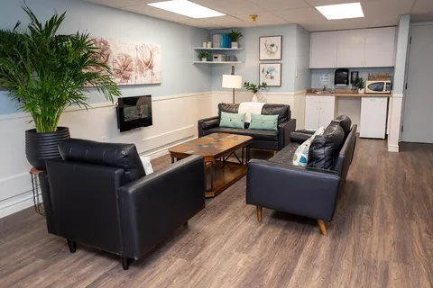 Lounge with armchairs, tables and a kitchenette.