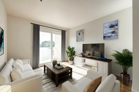 Sitting area with a sofa, armchairs, television and balcony door