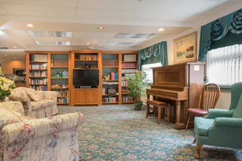 Library lounge with bookcases, sofas and a piano.