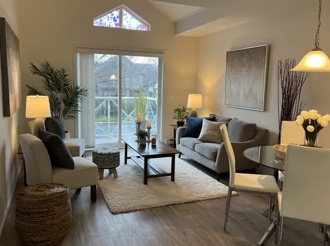 Suite sitting area with a sofa, armchairs and glazed balcony doors.