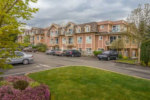 Three-storey residence viewed across the parking area and lawn.