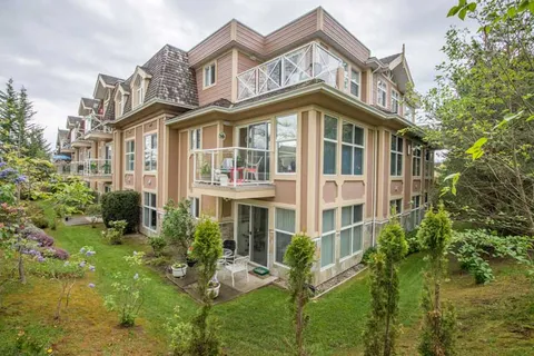 Residence exterior with balconies, bay windows and landscaped beds.