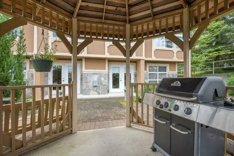 Covered outdoor pavilion with a barbecue beside the residence.