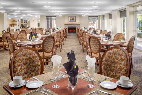 Dining room with set tables, patterned chairs and a fireplace