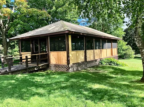 Gazebo surrounded by lawn and flower beds