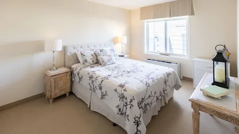Bedroom with a floral bedspread and pale wooden furniture