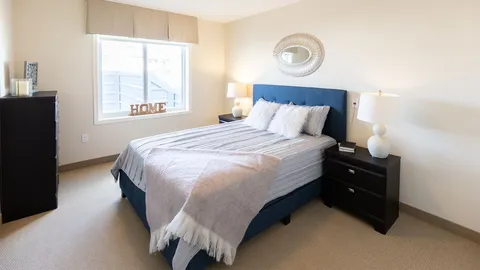 Bedroom with a blue upholstered bed and dark bedside tables