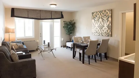 Room with sofas, armchairs, a dining table and a glass balcony door