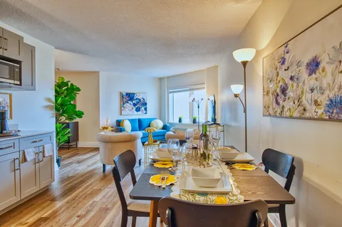 Suite dining area with a set table, chairs and kitchenette.