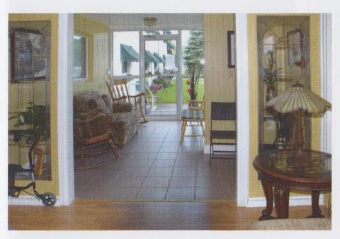 Lobby with chairs, tiled flooring and glass entrance doors.