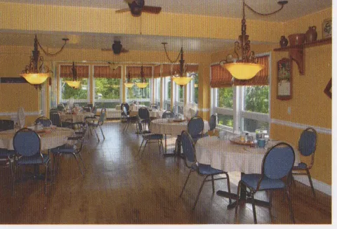 Dining room with round tables and windows.