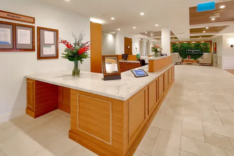 Reception desk beside a tiled entrance hall