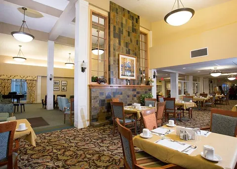 Dining room with set tables, chairs and pendant lights.