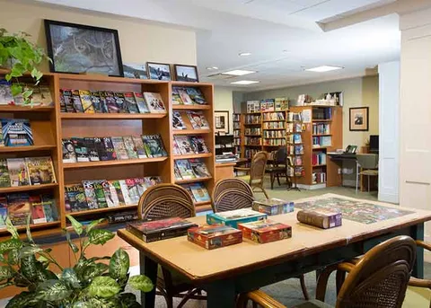 Library and games area with bookshelves and a large table.