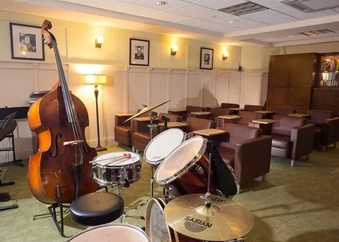 Music room with instruments, tables and chairs.