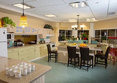 Communal kitchen and dining counter with stools.
