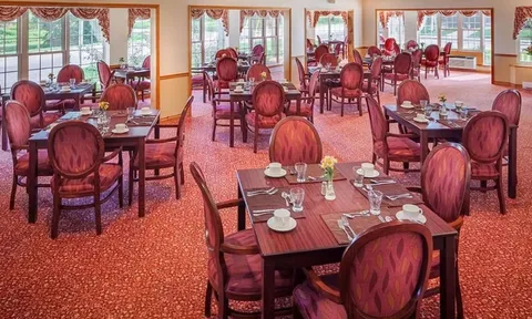 Dining room with red chairs and tables beside large windows