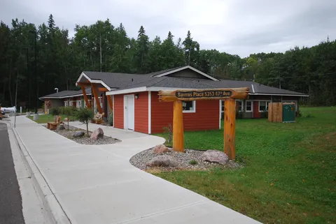 Exterior of Surerus Place beside its roadside sign and paved path.