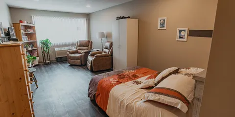 Studio suite with a bed, sofa and bookcase.