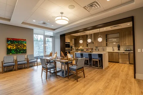 Room with chairs, tables, easels and a kitchenette