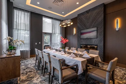 Dining table with upholstered chairs beneath pendant lights