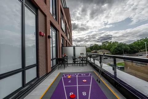 Terrace with a shuffleboard court, tables and chairs beside the building
