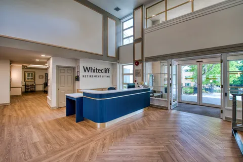 Entrance lobby with a reception desk, seating and glass doors.