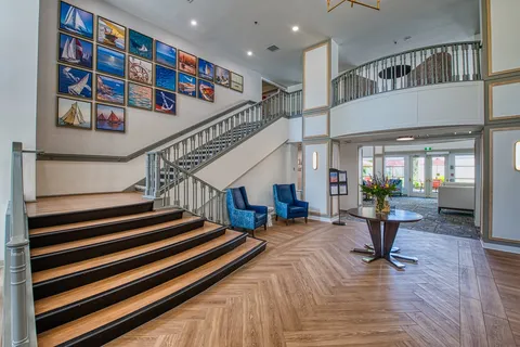 Lobby staircase with artwork and seating below the landing.