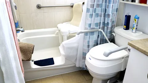 Bathroom with a bathtub, toilet and blue checked shower curtain