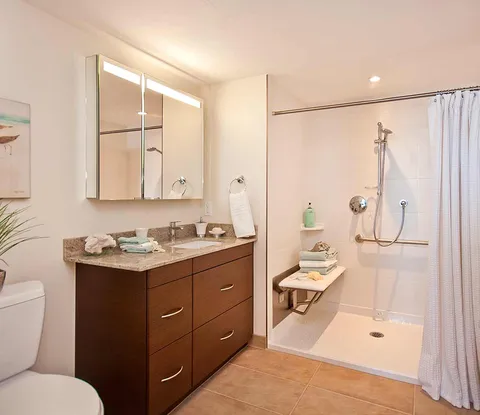 Bathroom with a shower, vanity cupboards, mirrored cabinet and toilet