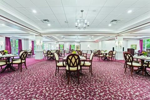 Dining room with round tables, wooden chairs and chandeliers