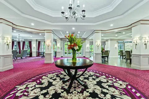 Lobby with a round flower table, chandelier and patterned carpet