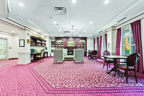 Room with bookcases, tables, chairs and a computer desk