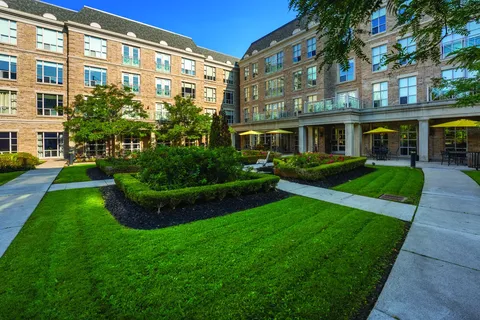 Brick building beside a landscaped lawn and paved paths