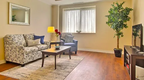 Sitting room with a sofa, armchair, coffee table and television