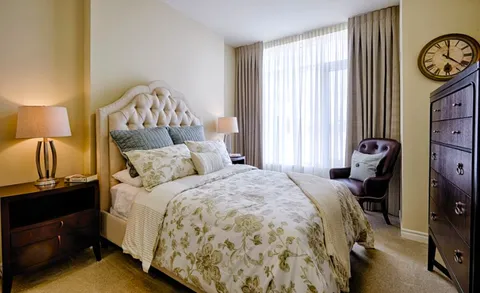 Bedroom with a double bed, dresser, armchair and window