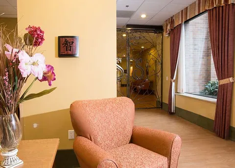 Seating corner with an armchair and orchid display.