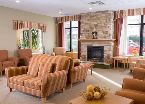 Lounge with striped armchairs, sofas and a stone fireplace.