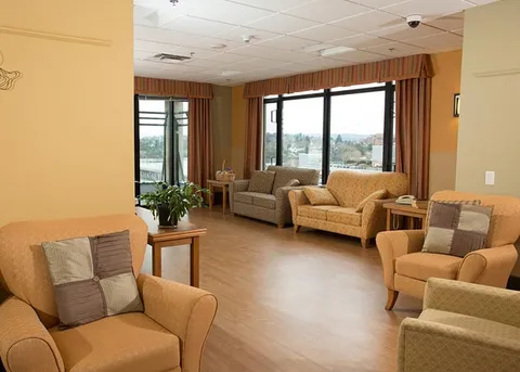Bright lounge with armchairs and large windows.
