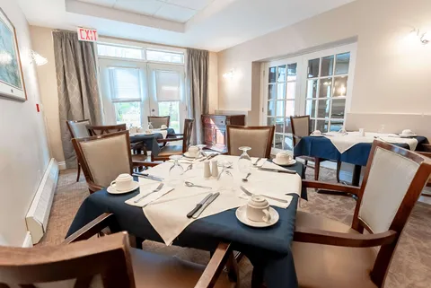 Dining room with round tables set with cups, glasses and cutlery