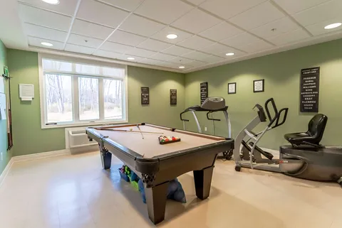 Room with a pool table, treadmill and exercise bicycle