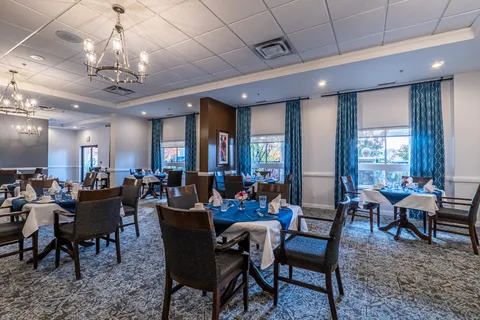 Dining room with set tables beneath chandeliers