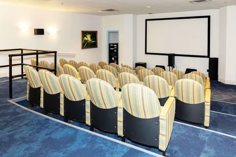 Rows of theatre seats facing a blank projection screen