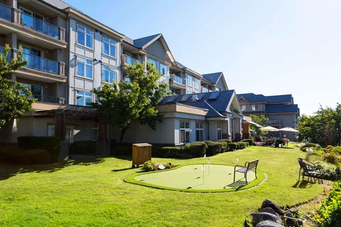 Multi-storey building beside a lawn, putting green and outdoor seating